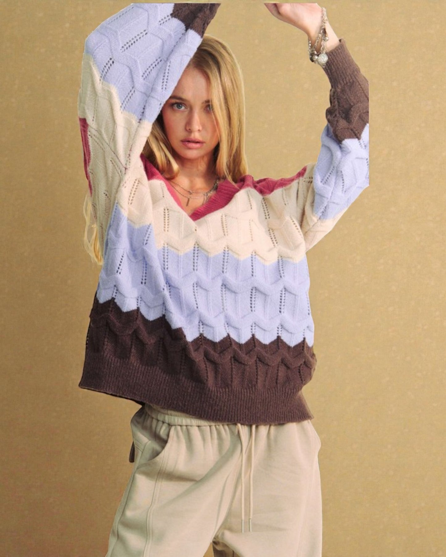 Woman wearing a colorful, patterned sweater against a beige background
