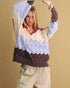 Woman wearing a colorful, patterned sweater against a beige background