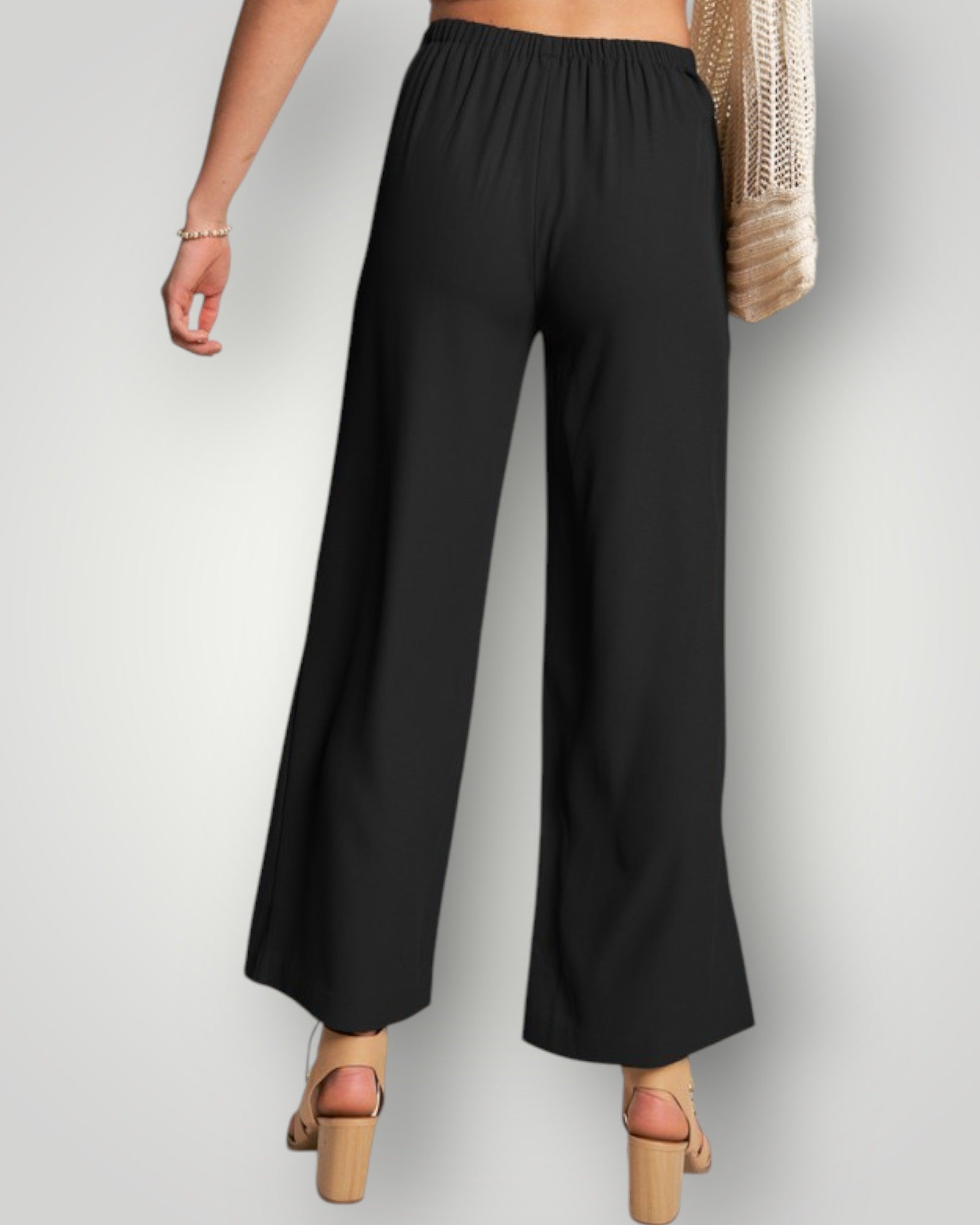 Black wide-leg pants worn by a person on a light gray background