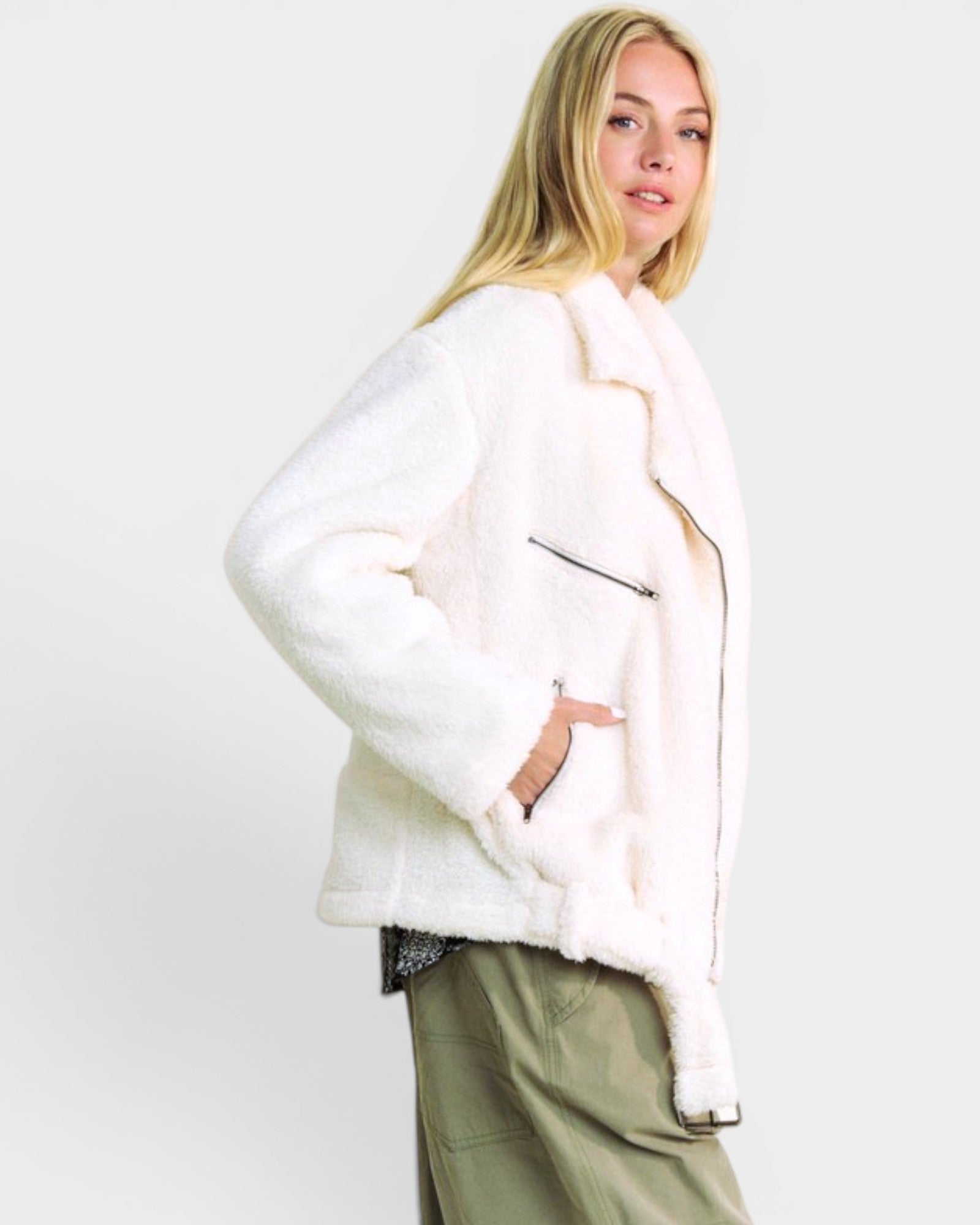 Woman wearing a white fur coat against a plain background