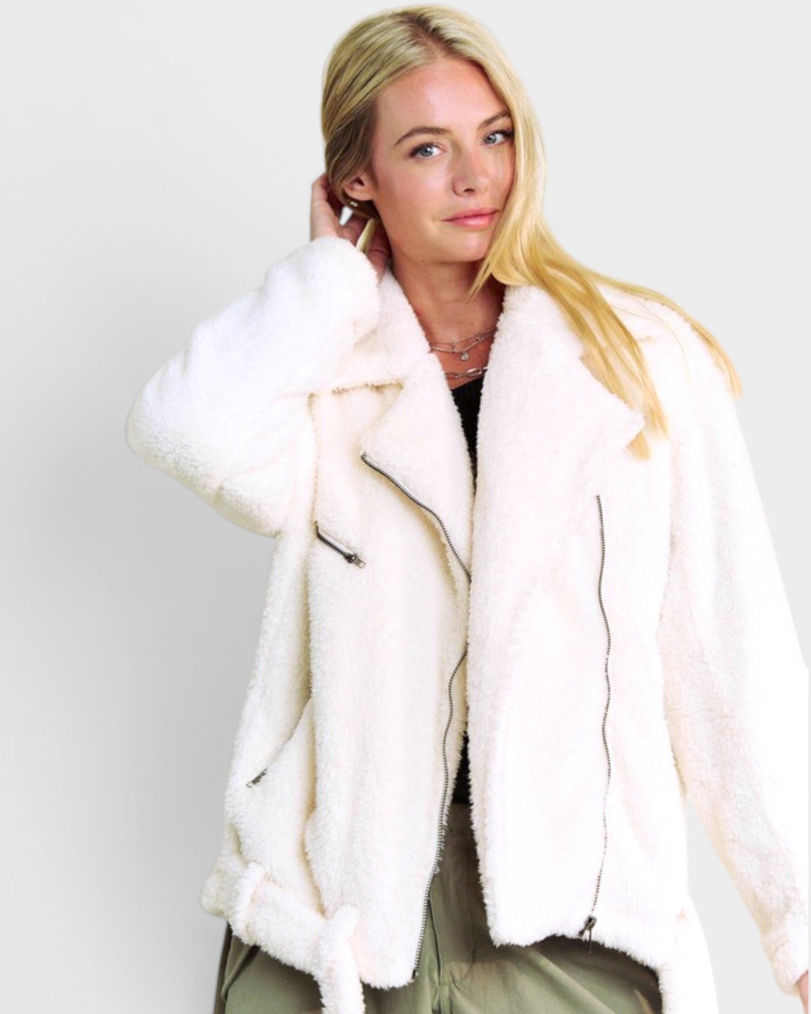 Woman wearing a white fur coat against a plain background