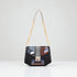 Black handbag with geometric pattern and gold chain strap on a white background