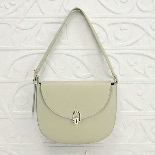 Light green handbag with a gold clasp on a textured white background