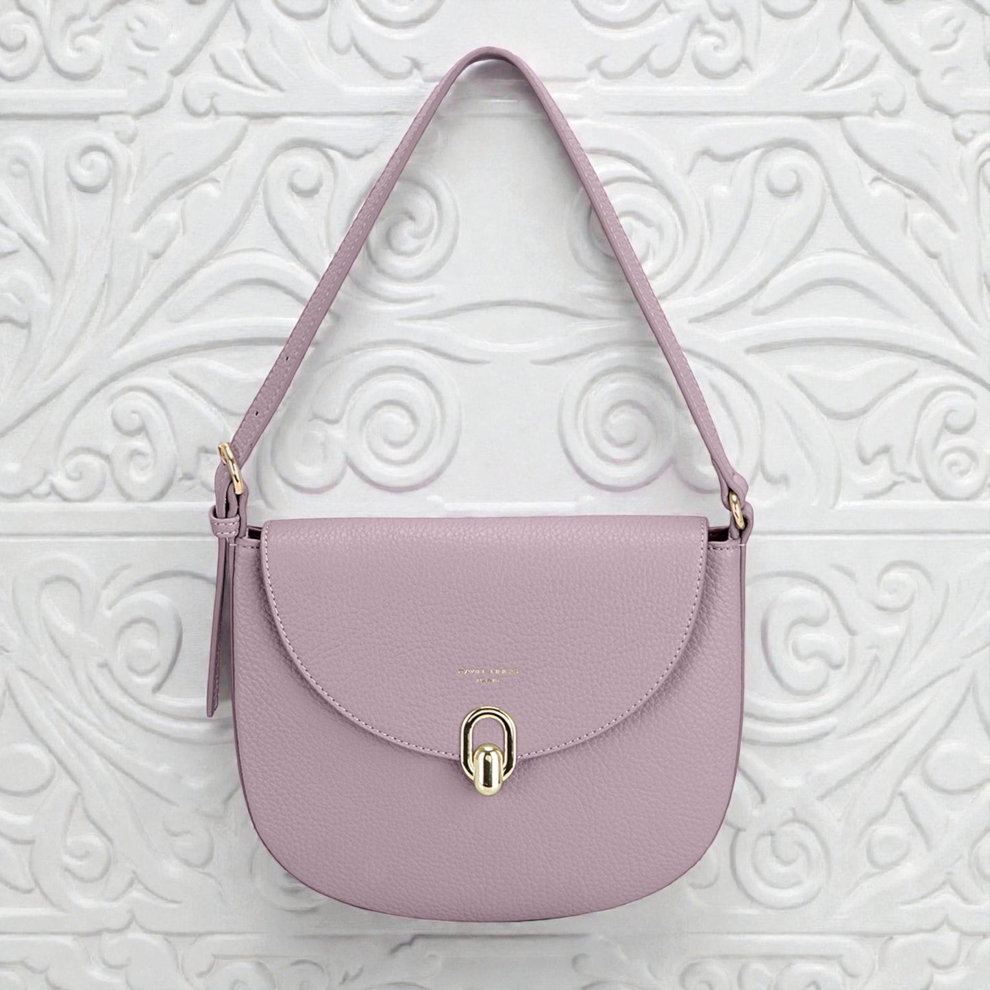 Purple handbag with a gold clasp on a white textured background