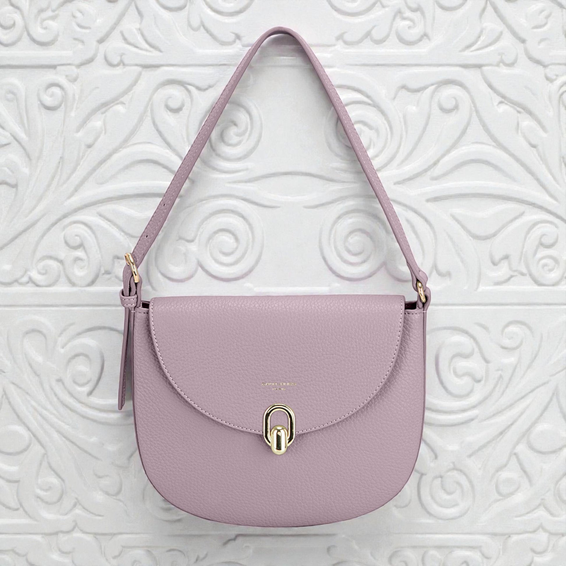 Purple handbag with a gold clasp on a white textured background