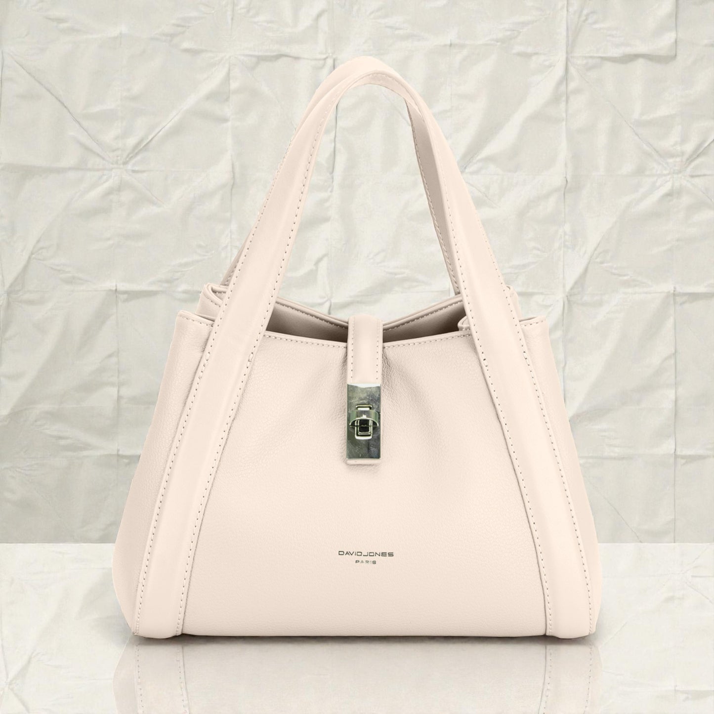 Beige handbag with a visible brand name on a light gray background