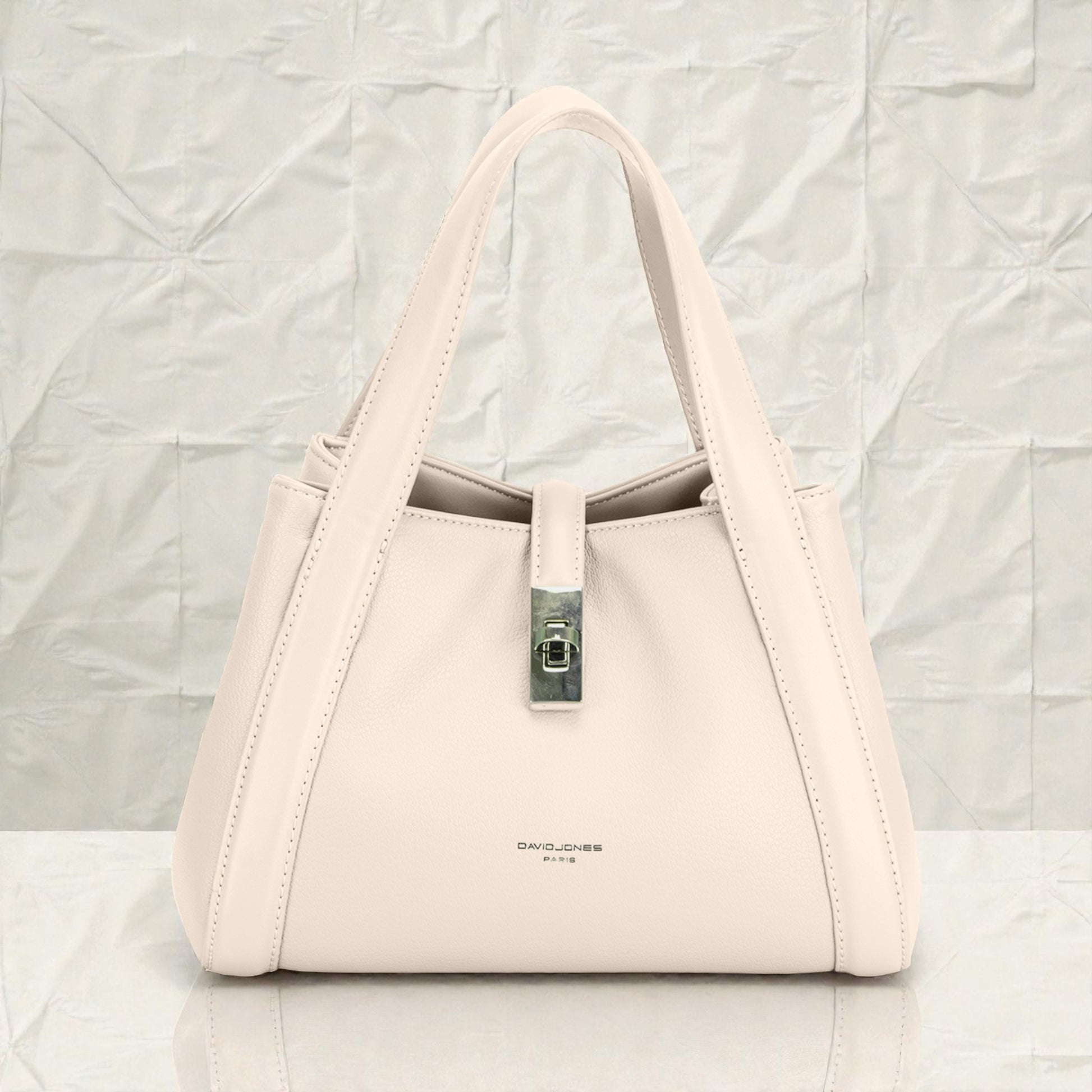 Beige handbag with a visible brand name on a light gray background