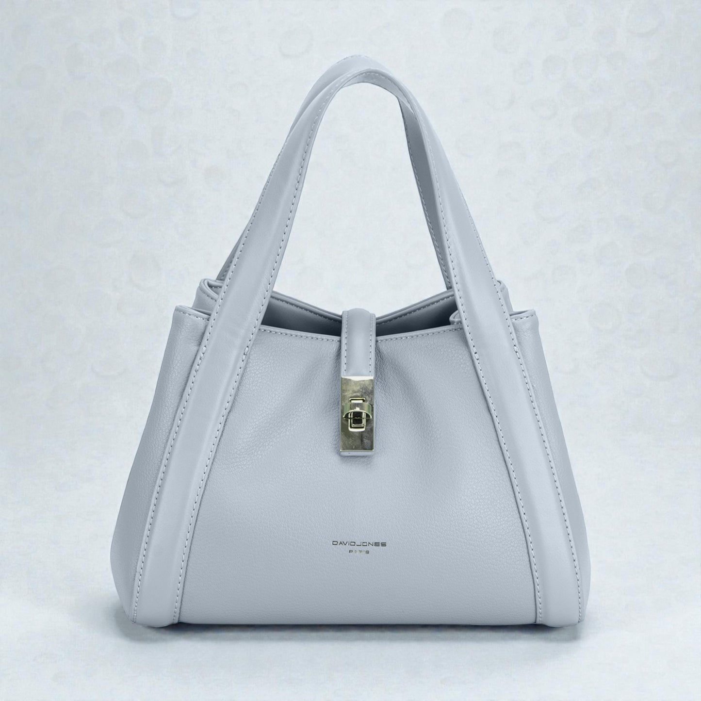 Light gray handbag with a silver clasp on a light gray background