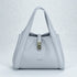 Light gray handbag with a silver clasp on a light gray background