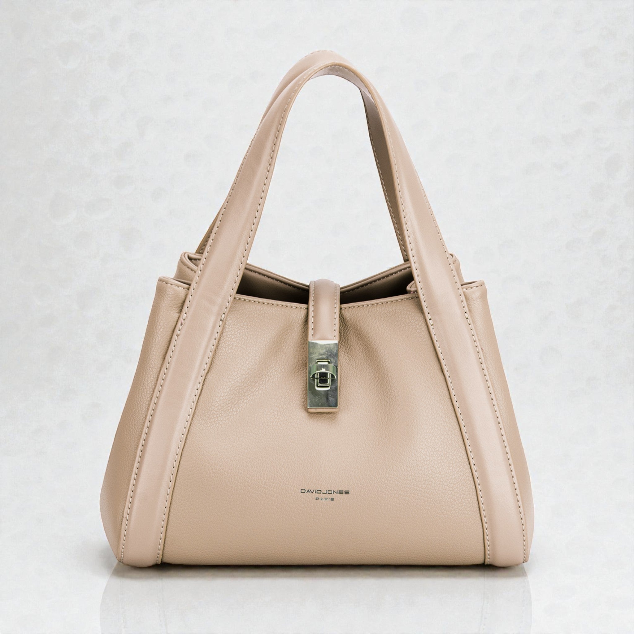 Beige handbag with a silver clasp on a light gray background