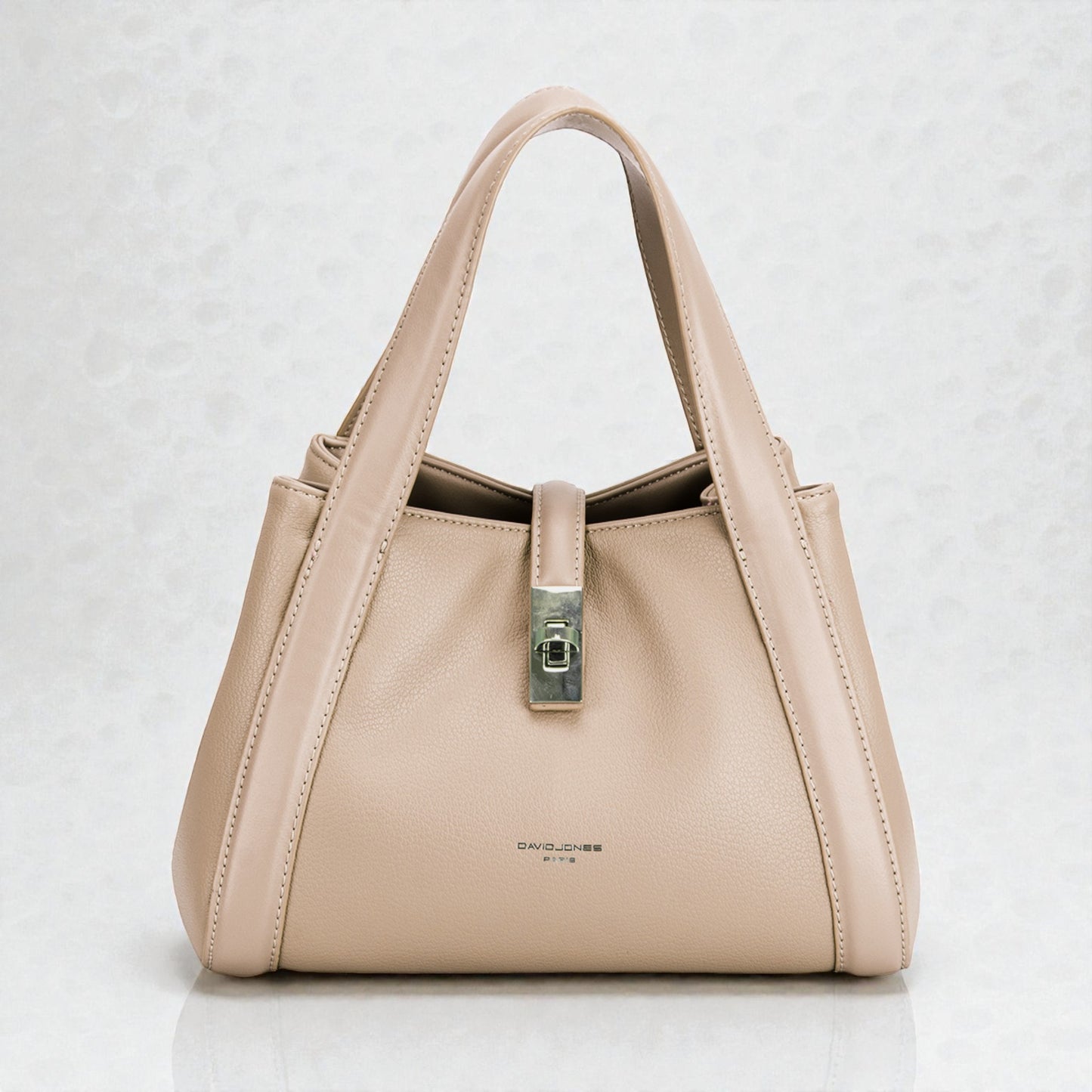 Beige handbag with a silver clasp on a light gray background