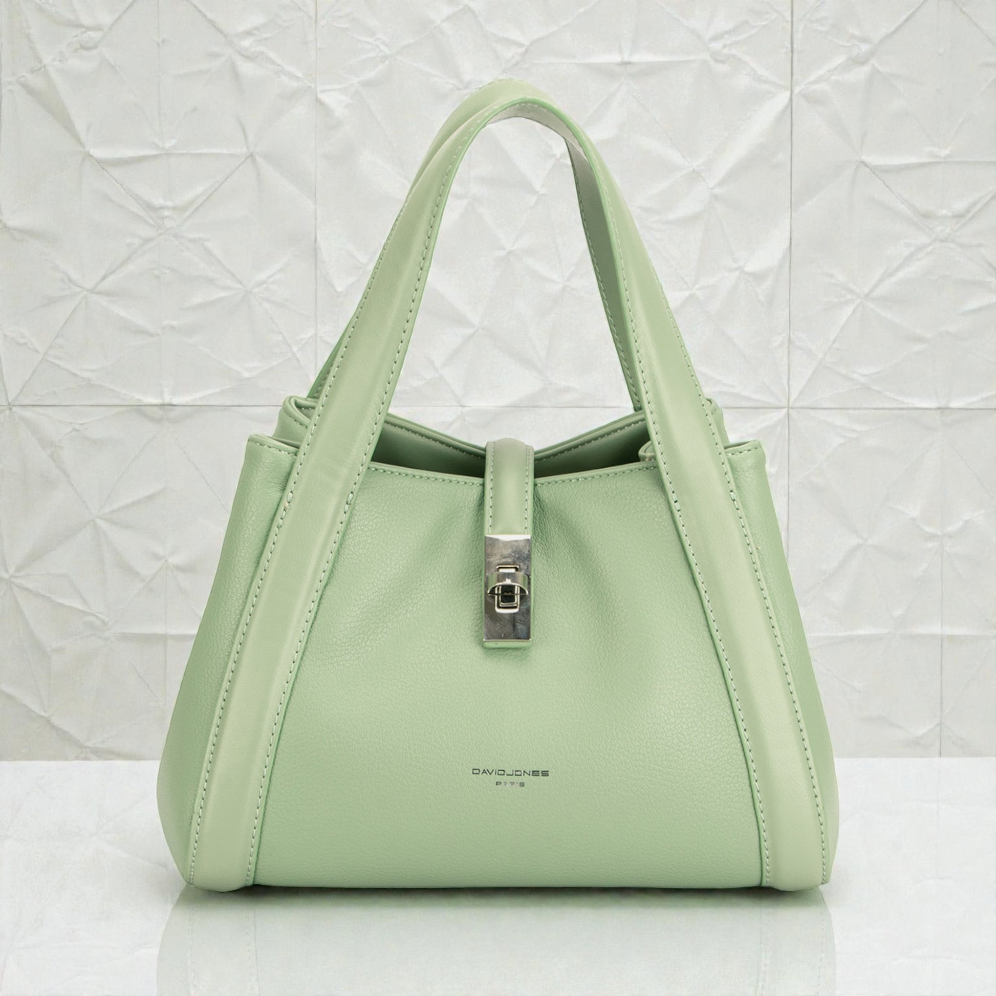 Light green handbag with a silver clasp on a white background