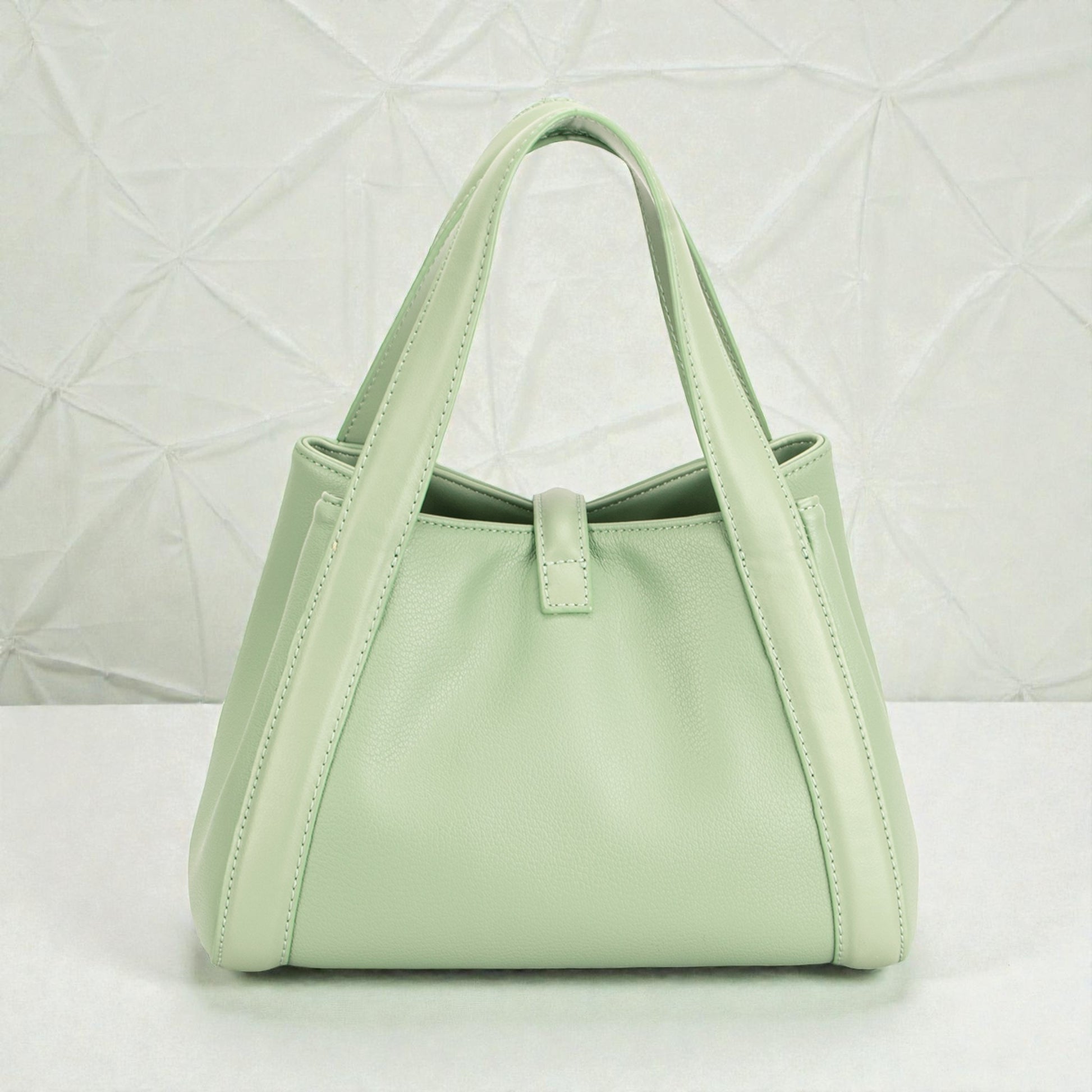 Mint green handbag on a light gray background
