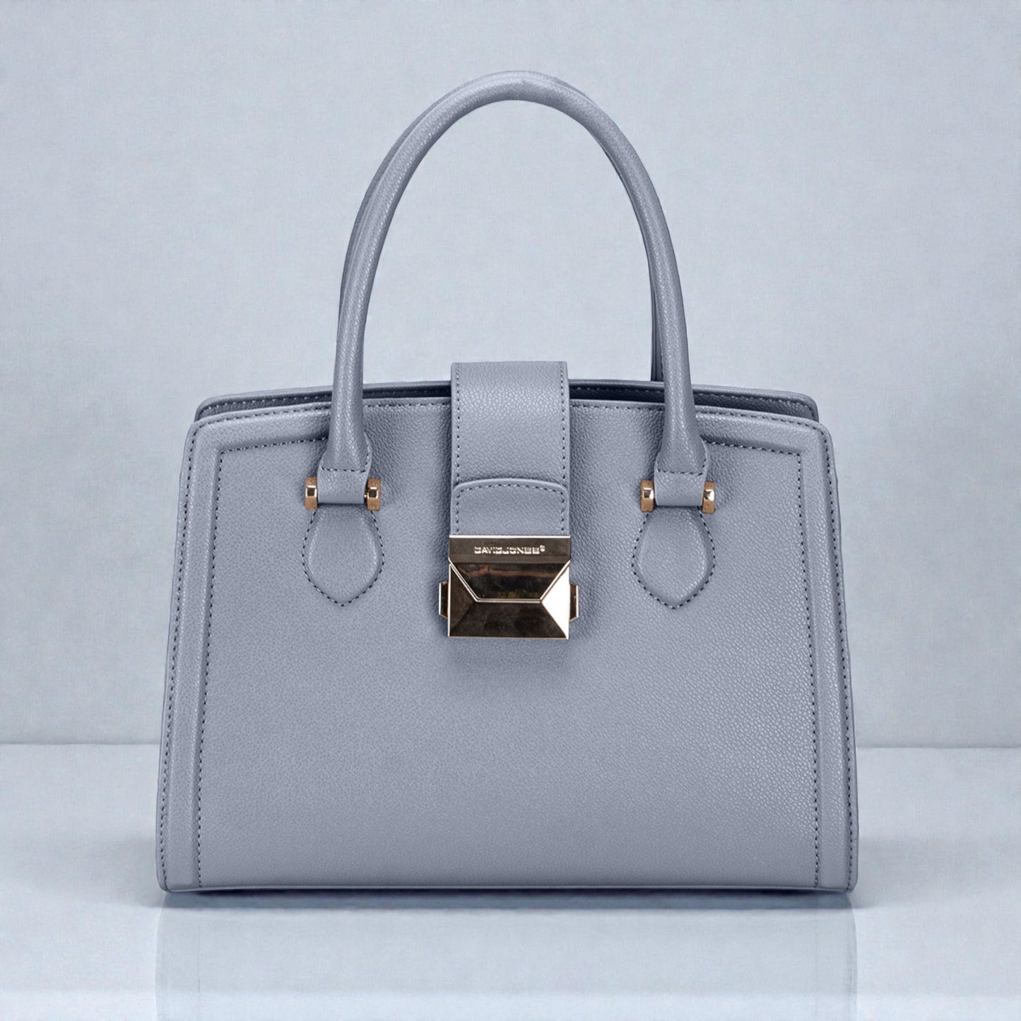Gray handbag with gold accents on a light gray background