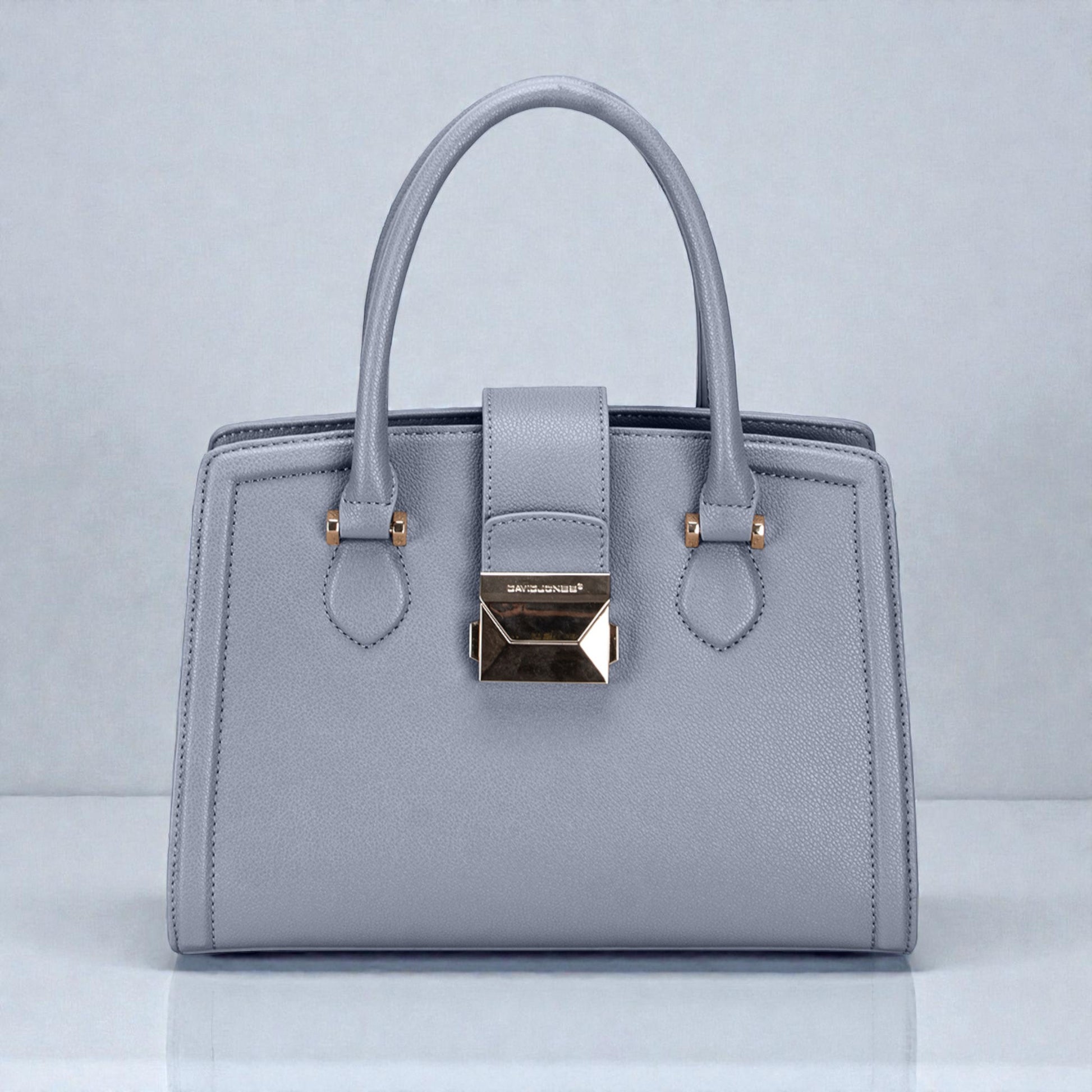 Gray handbag with gold accents on a light gray background