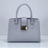Gray handbag with gold accents on a light gray background