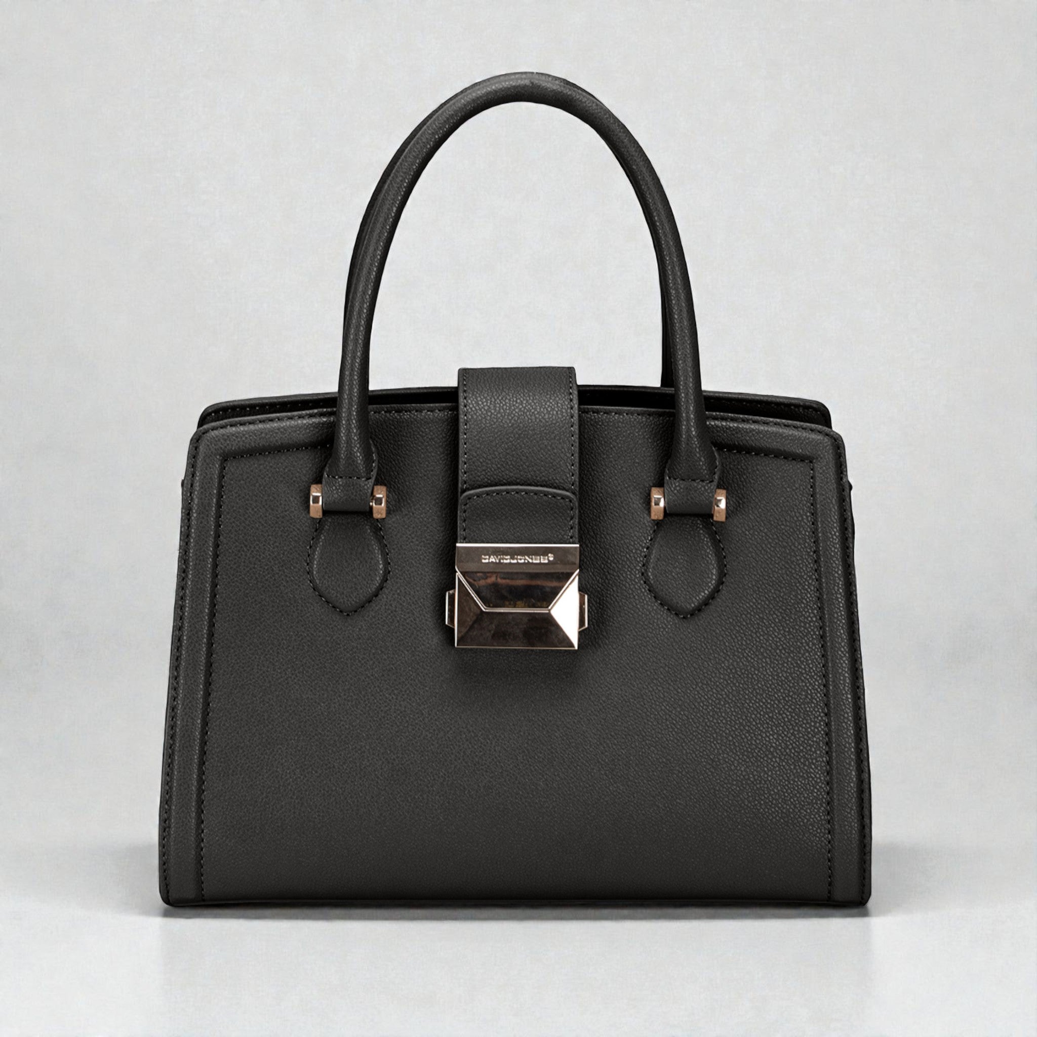 Black handbag with a silver clasp on a light gray background