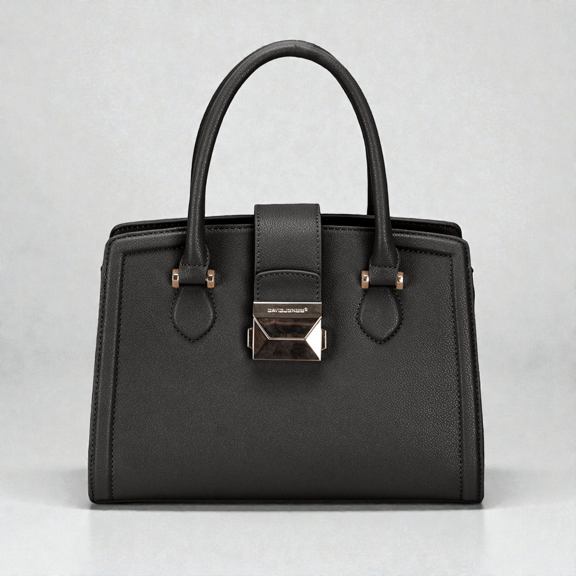 Black handbag with a silver clasp on a light gray background