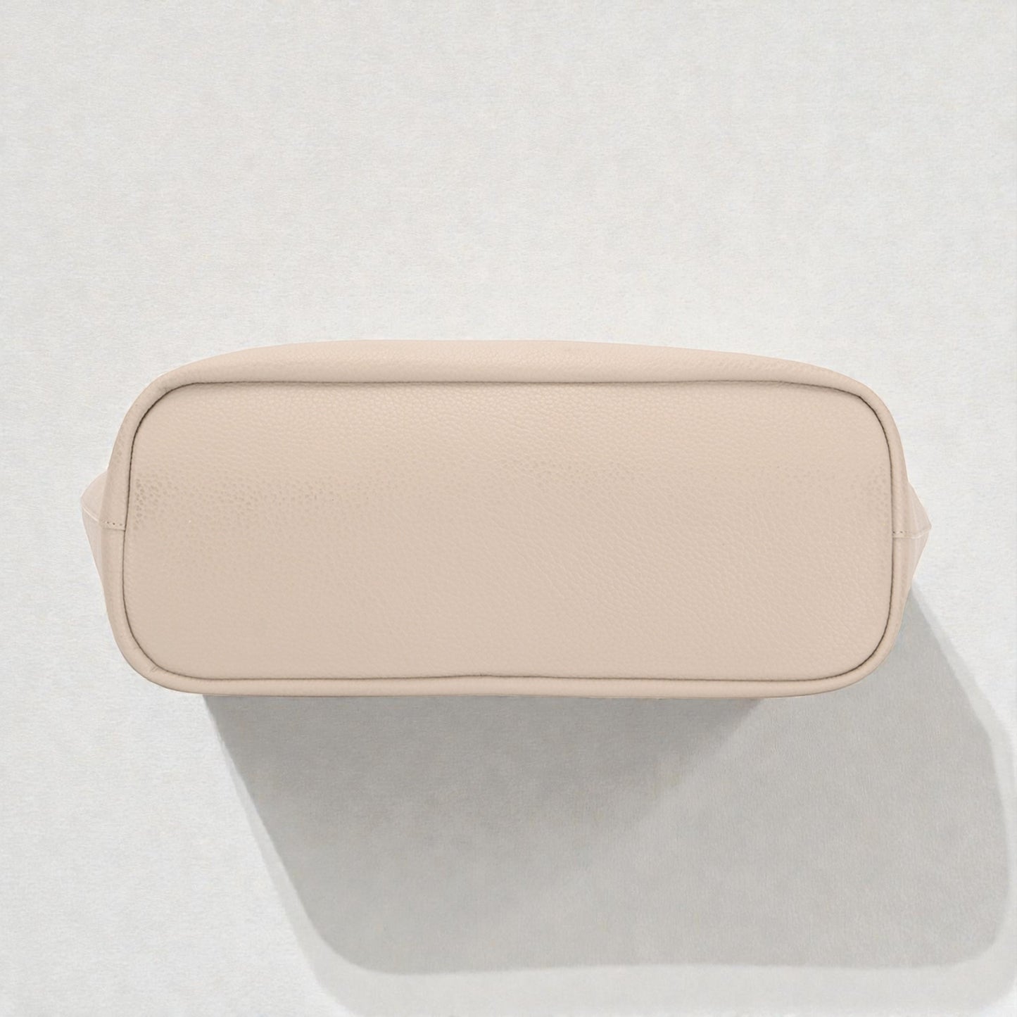 Beige toiletry bag on a light gray background
