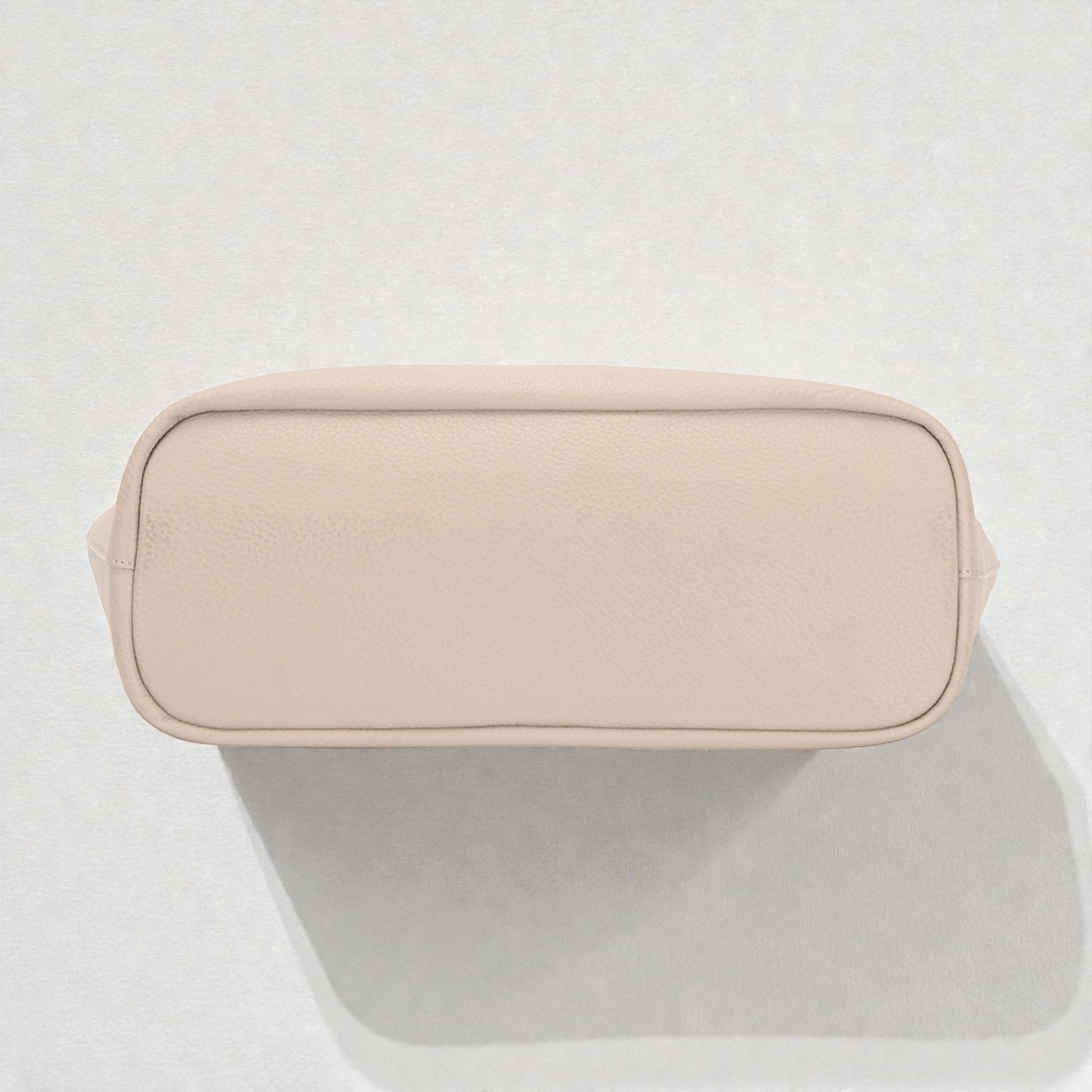 Beige toiletry bag on a light gray background