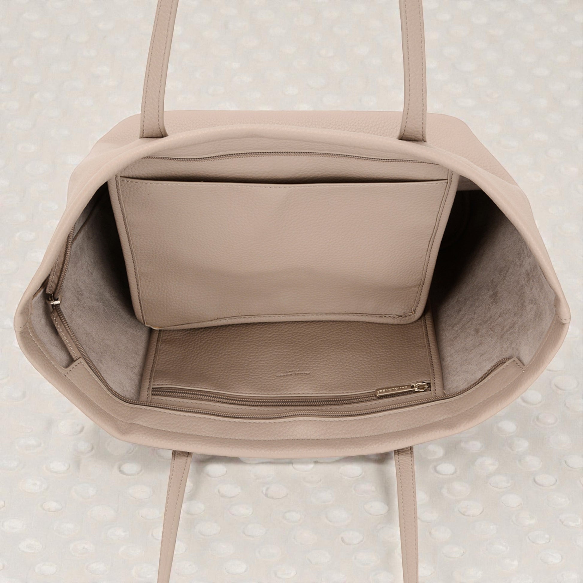 Beige handbag with a textured surface on a light background