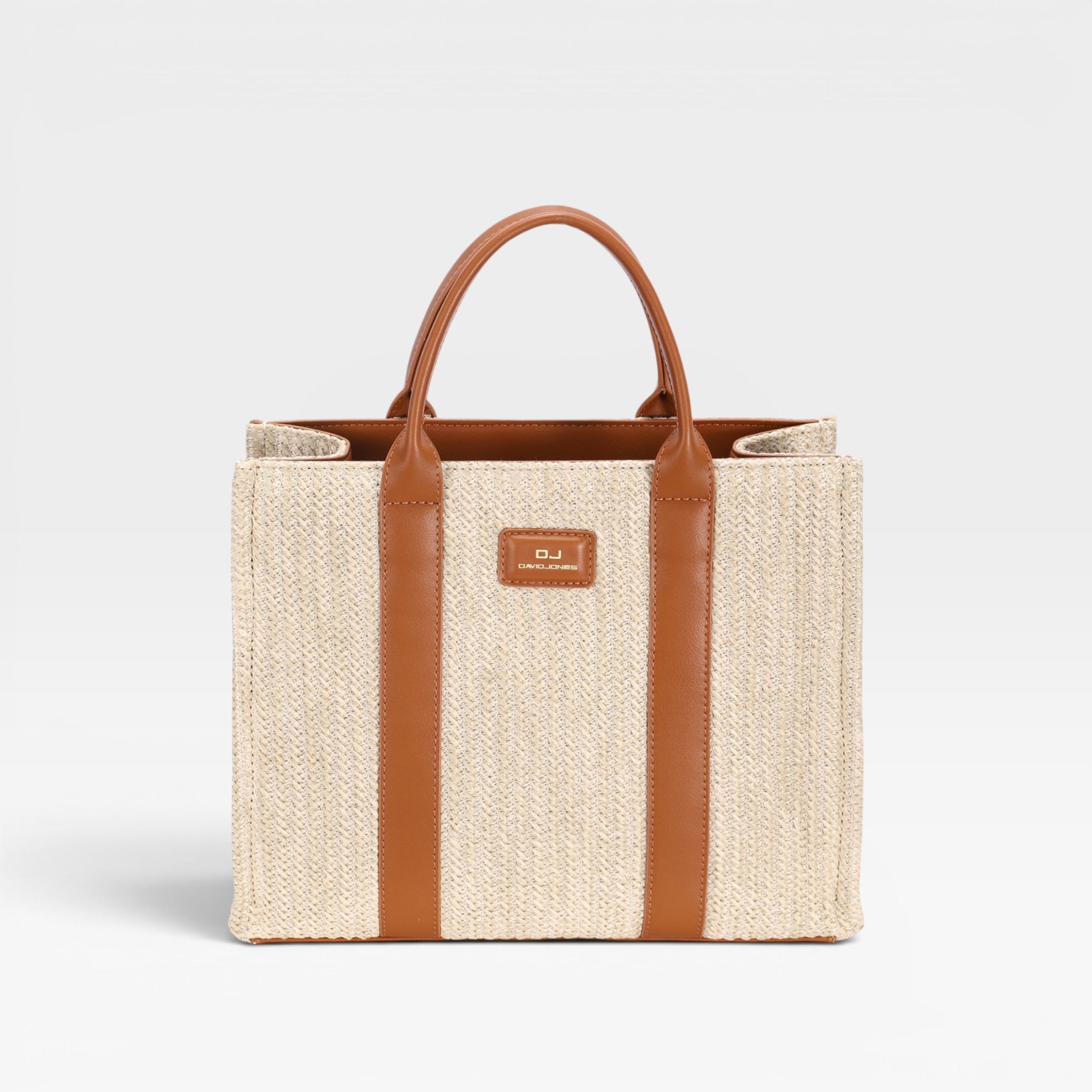 Woven tote bag with brown straps and handle on a light gray background