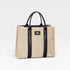 Beige straw tote bag with black straps on a light gray background