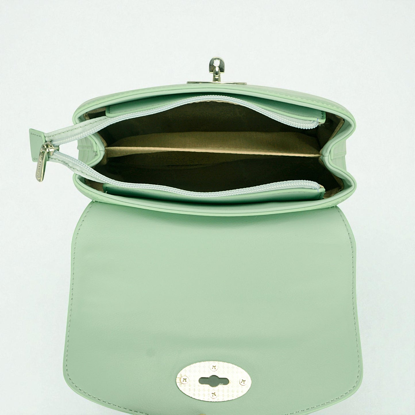 Mint green handbag with a reflective surface on a light gray background