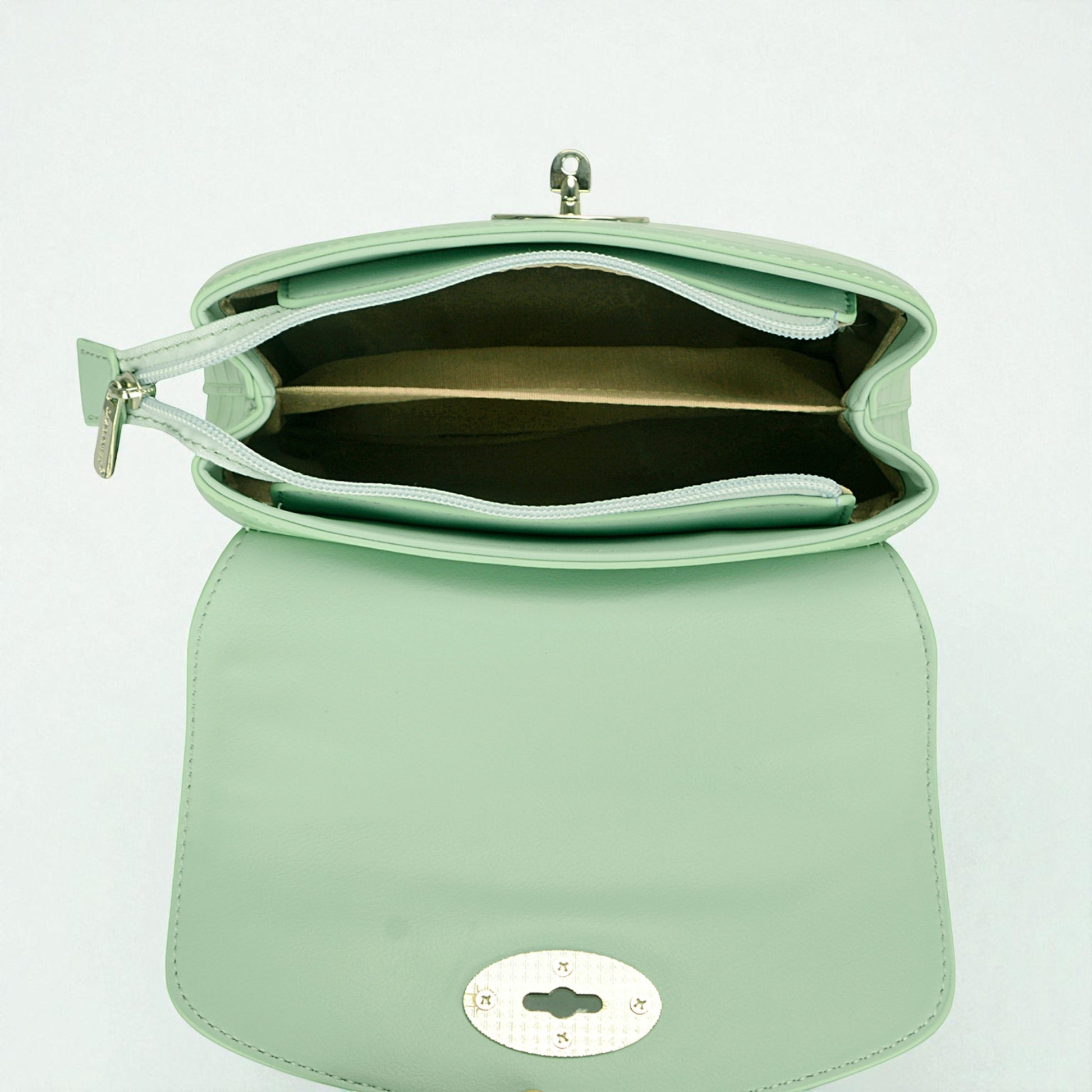 Mint green handbag with a reflective surface on a light gray background