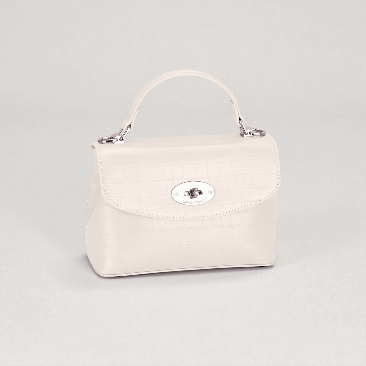 White handbag with a silver clasp on a light gray background