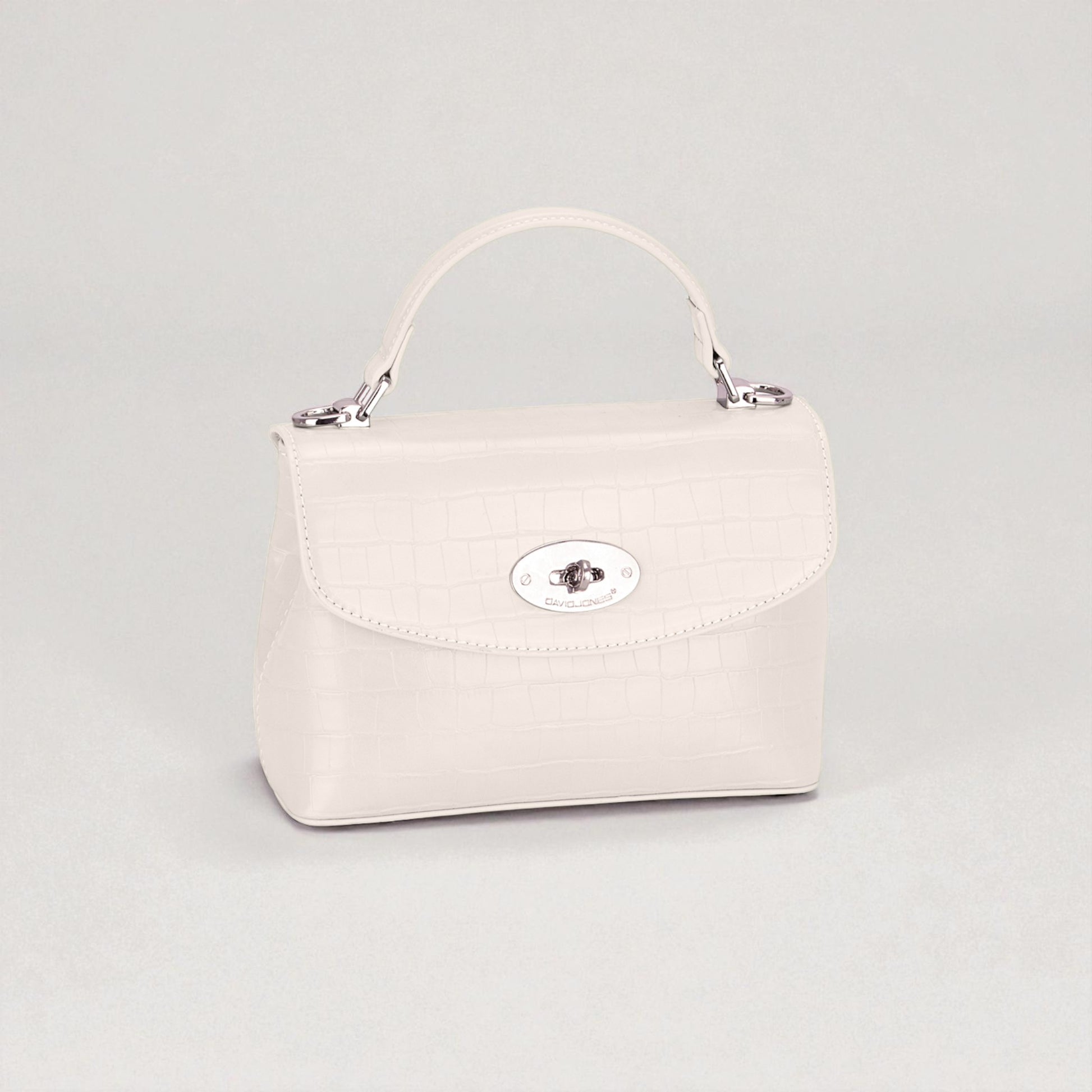 White handbag with a silver clasp on a light gray background