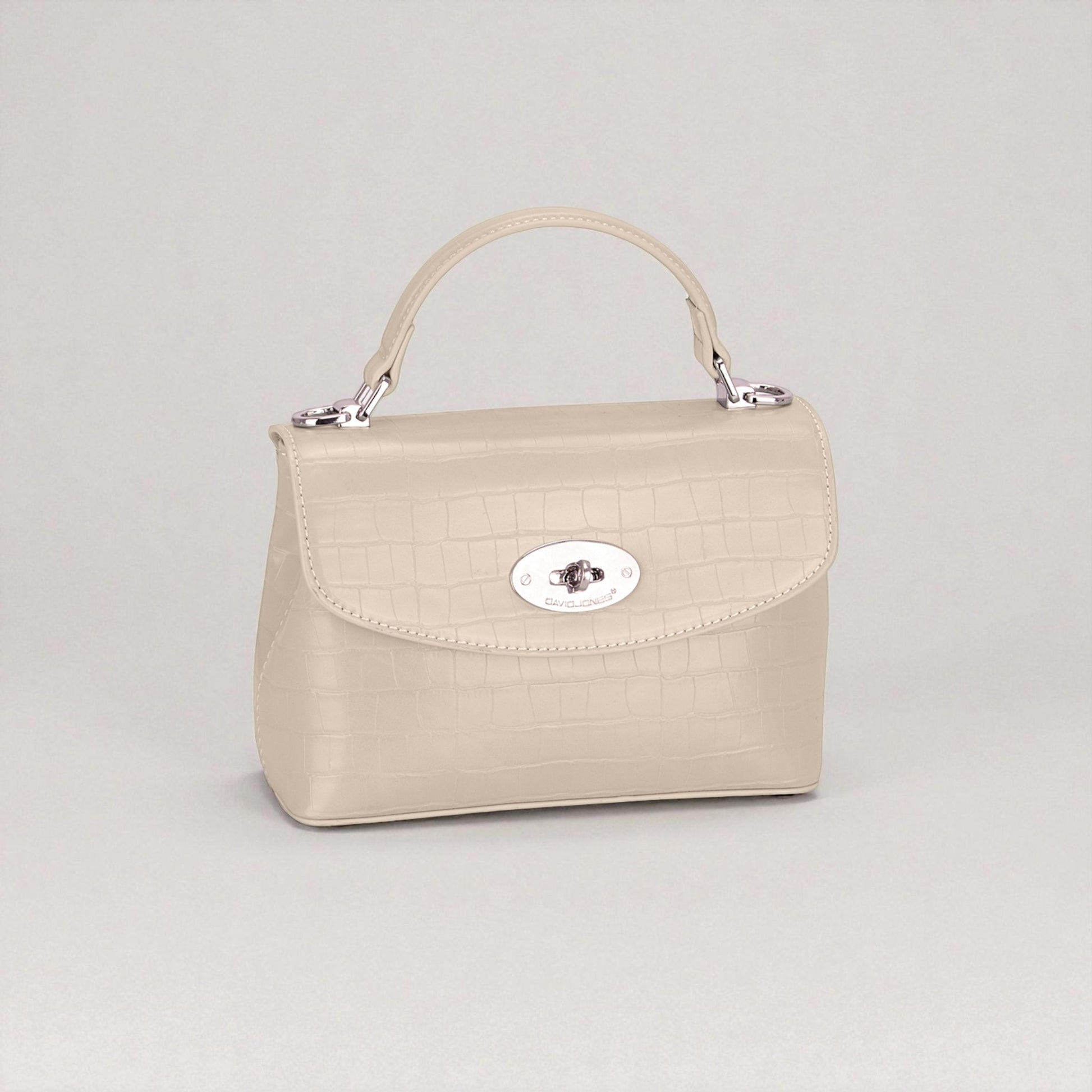 Beige handbag with a silver clasp on a light gray background