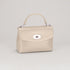 Beige handbag with a silver clasp on a light gray background