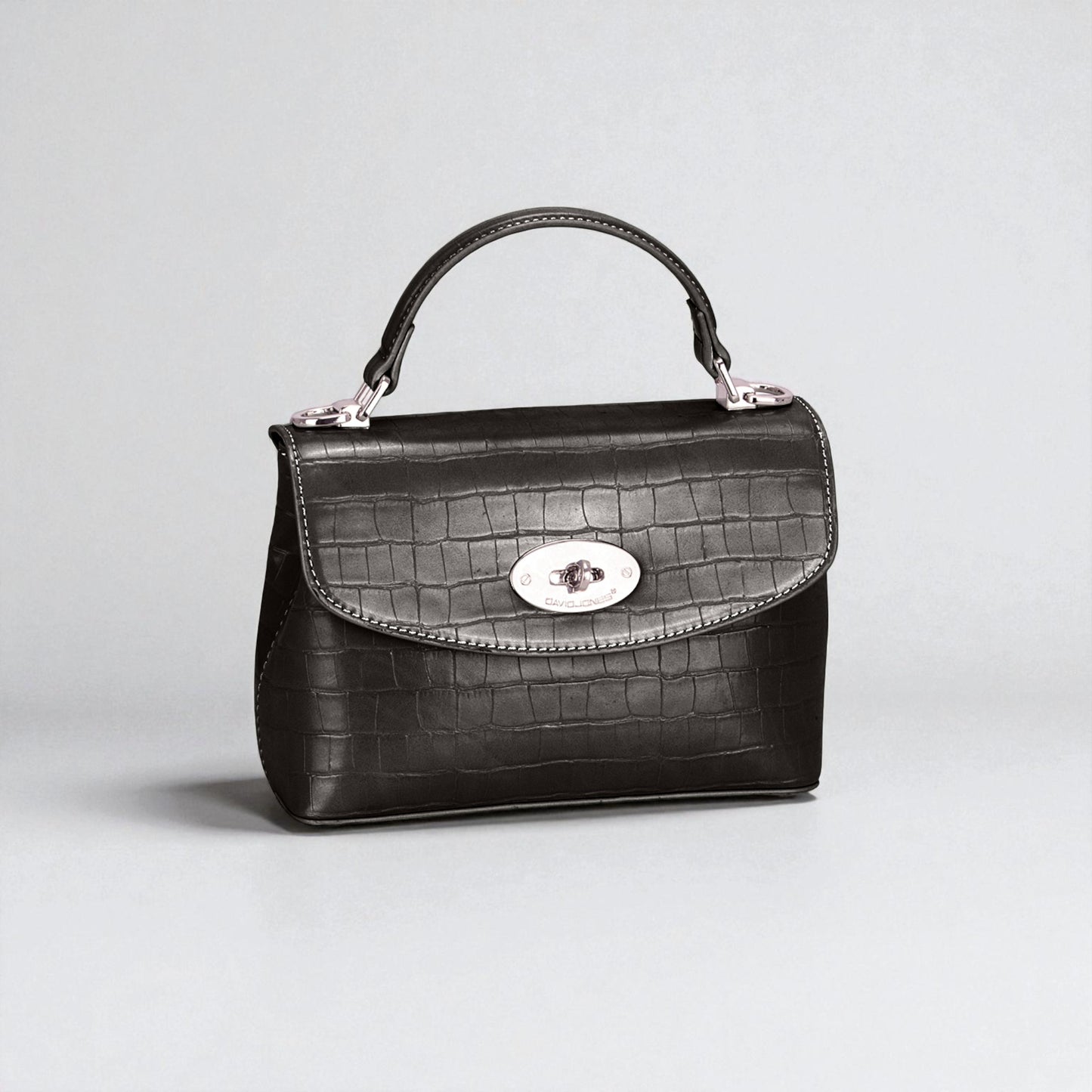 Black crocodile-patterned handbag on a light gray background
