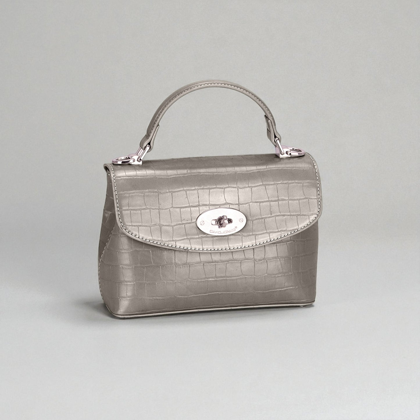 Silver handbag with a textured pattern on a light gray background