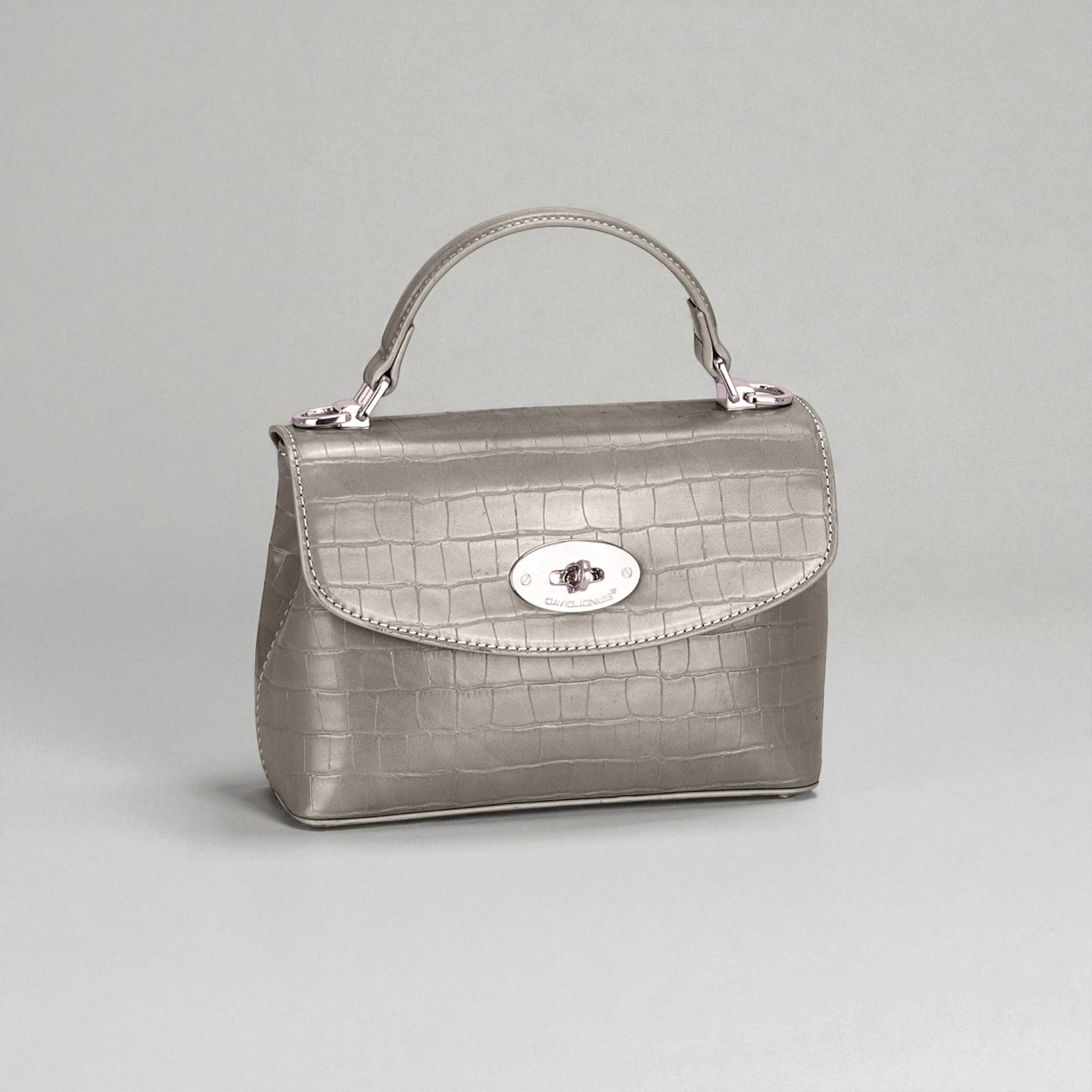 Silver handbag with a textured pattern on a light gray background
