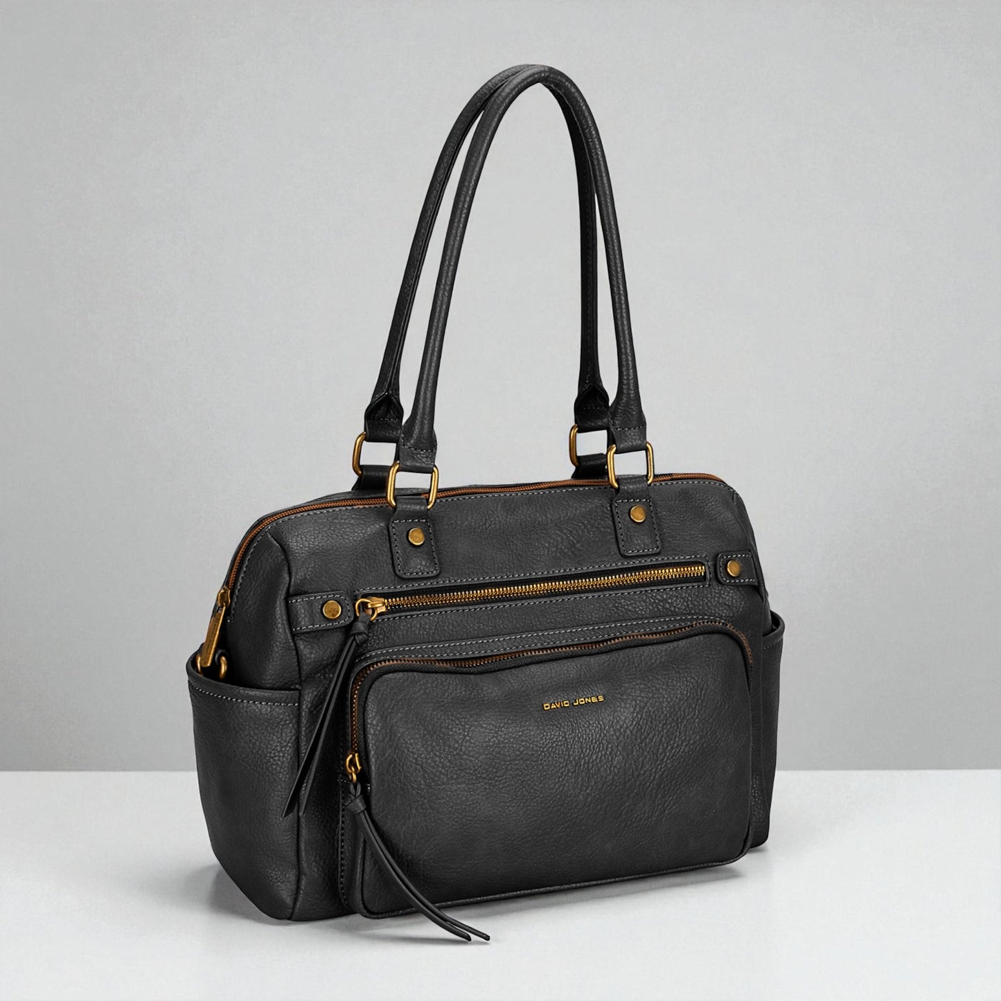 Black handbag with gold accents on a gray background