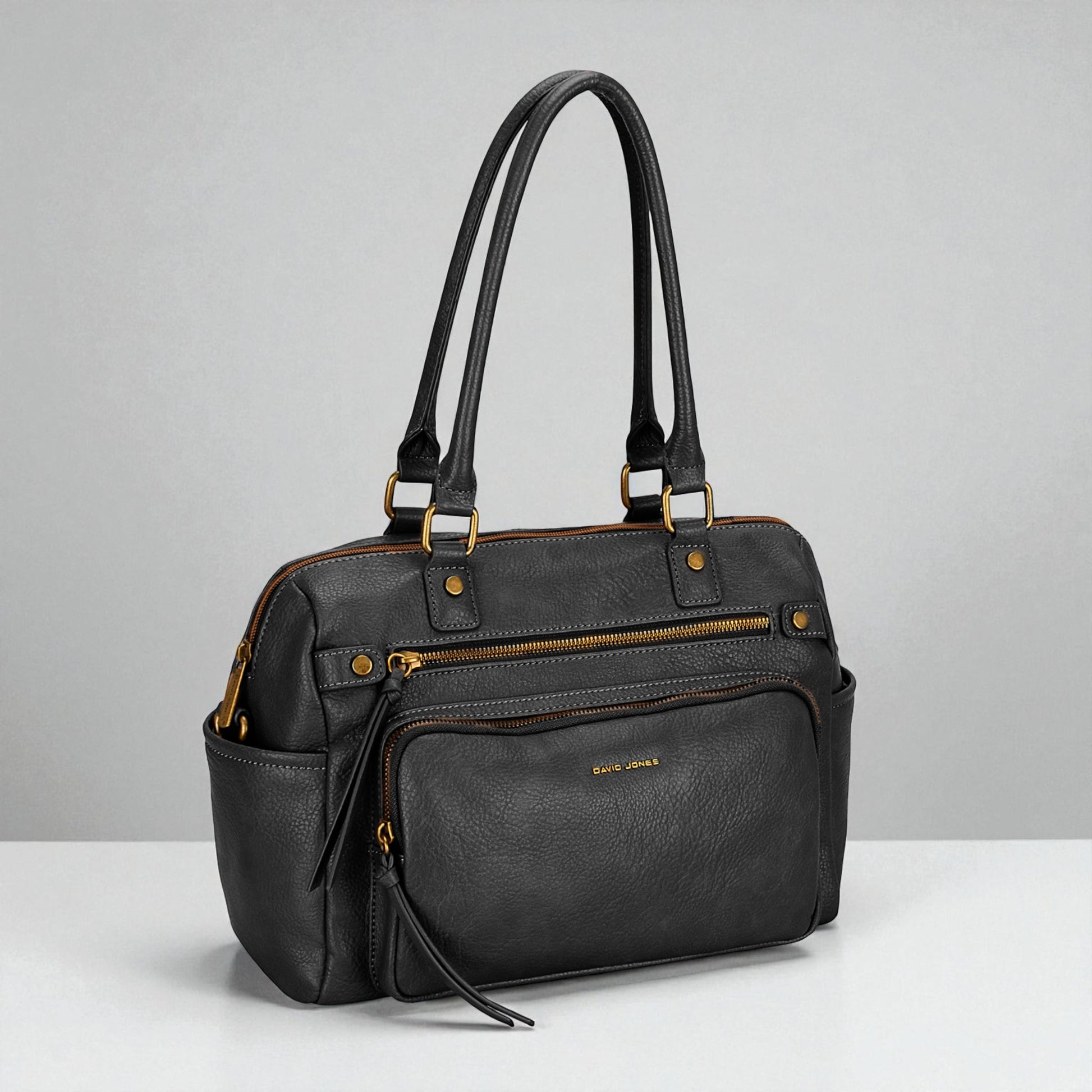 Black handbag with gold accents on a gray background