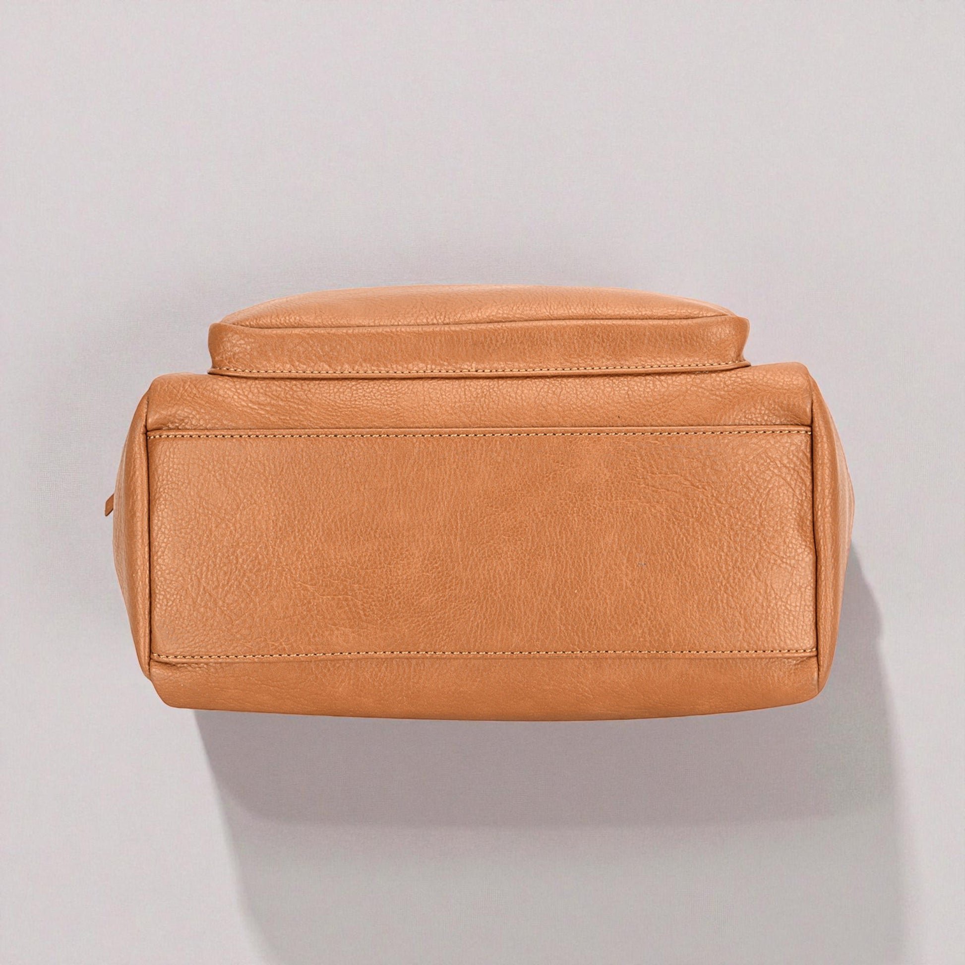 Brown leather toiletry bag on a light gray background