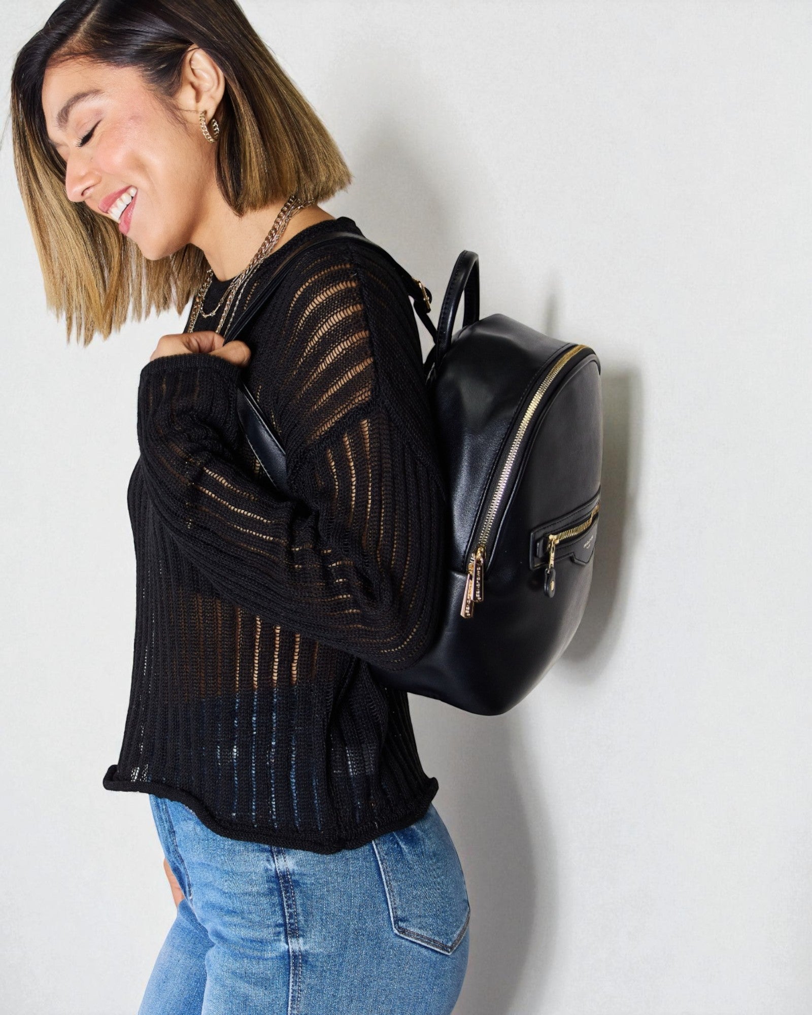Woman wearing a black backpack against a white background