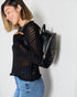 Woman wearing a black backpack against a white background