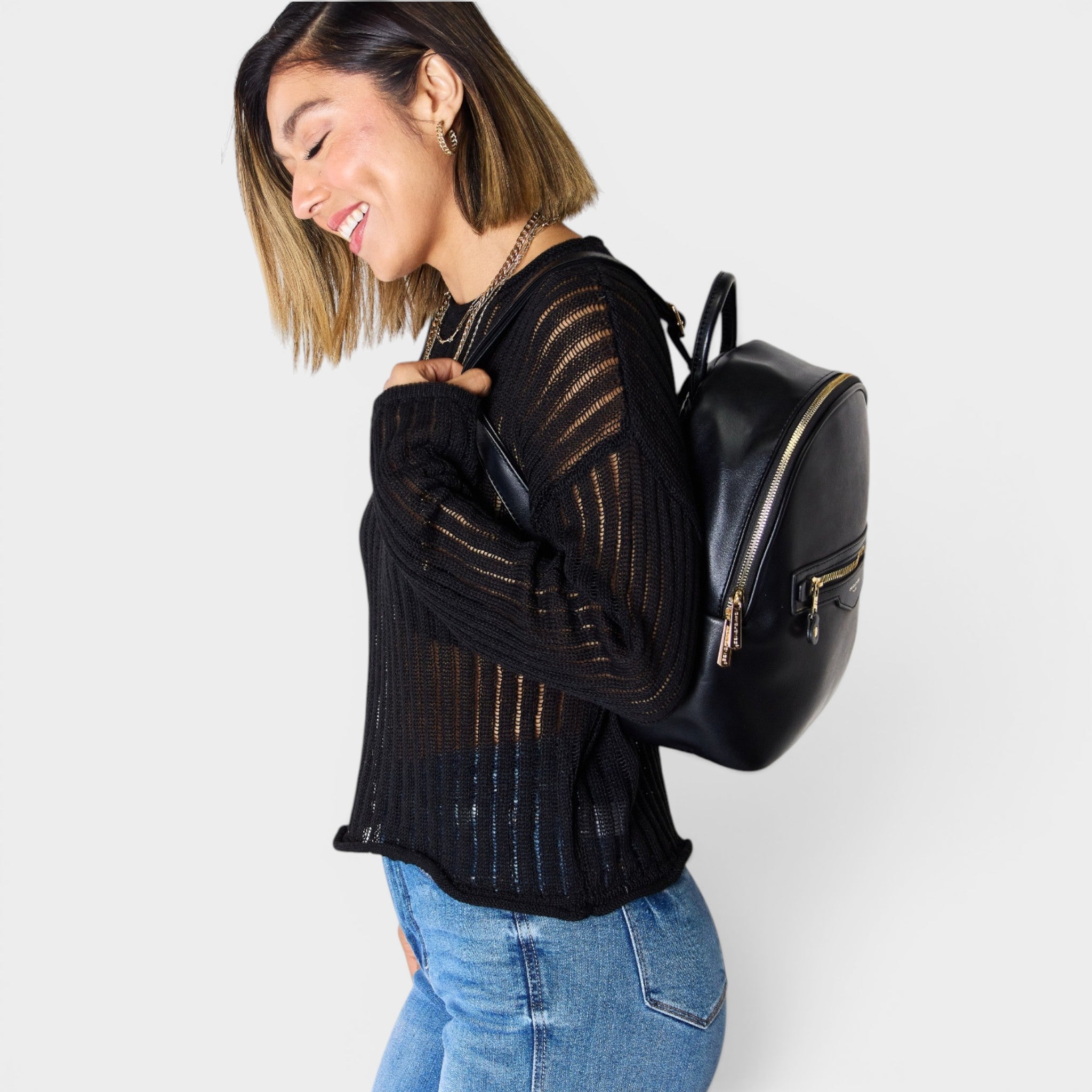 Woman wearing a black backpack against a white background