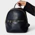 Black backpack held by a hand on a light gray background