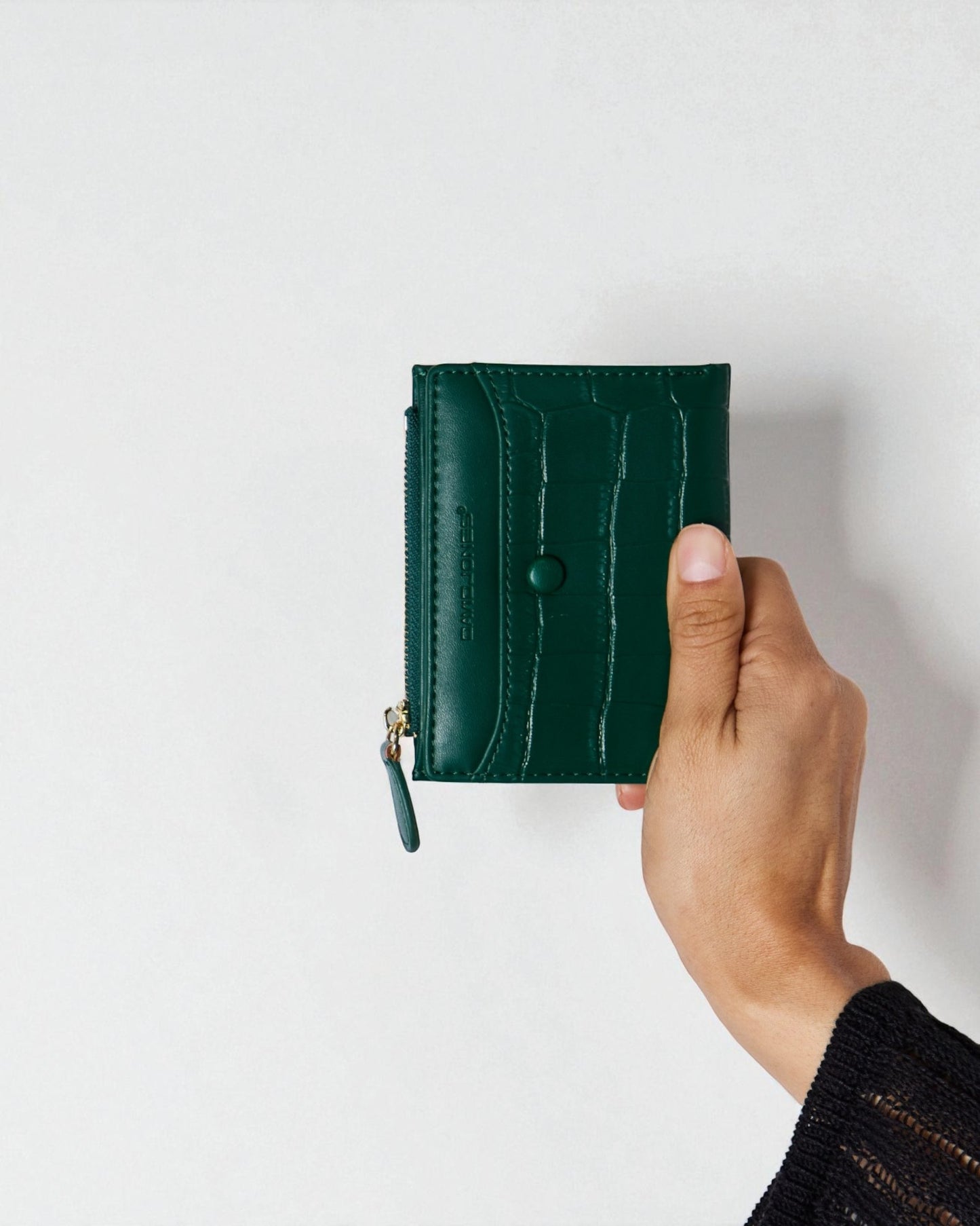 Hand holding a green wallet against a white background