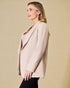 Woman wearing a beige blazer against a beige background