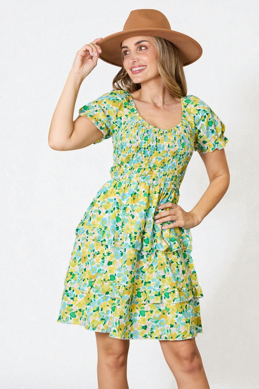 Woman wearing a floral dress and brown hat against a white background