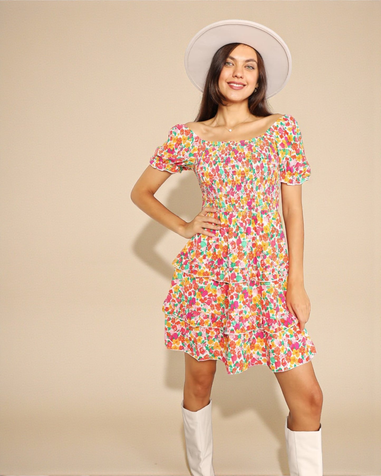 Woman wearing a colorful floral dress with a plain background