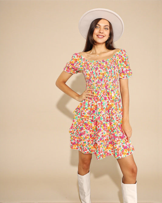 Woman wearing a colorful floral dress with a plain background