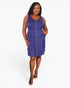 A woman modeling a sleeveless purple dress with a button-down front and side pockets, photographed against a plain light gray studio background.