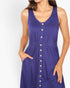 A woman wearing a sleeveless purple dress with a button-down front, side pockets, and a gathered waist, shown against a plain light background.